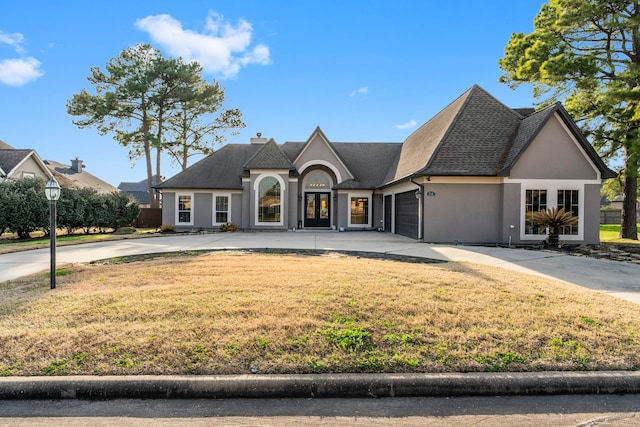 french country inspired facade with a garage and a front yard