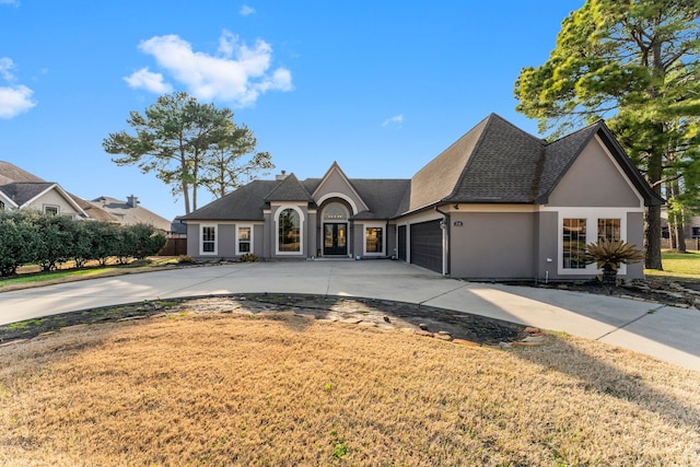 french country style house featuring a garage and a front yard