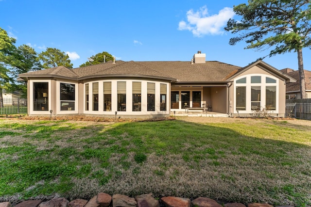 rear view of house with a lawn and a patio