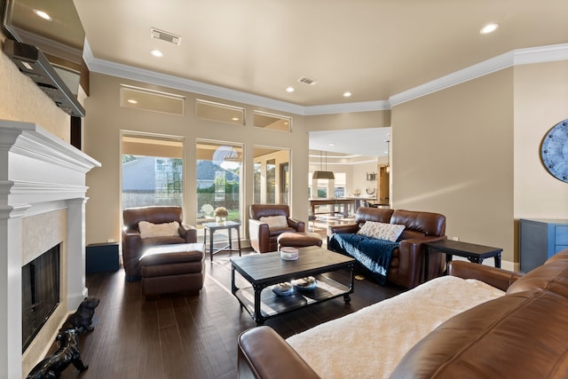 living room featuring dark wood-type flooring, a premium fireplace, and ornamental molding