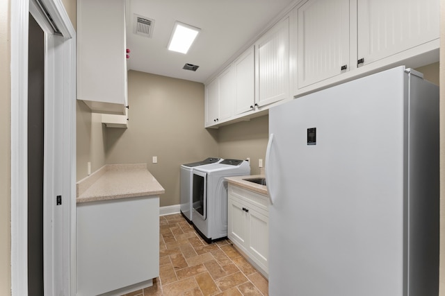 laundry room with cabinets and washing machine and clothes dryer