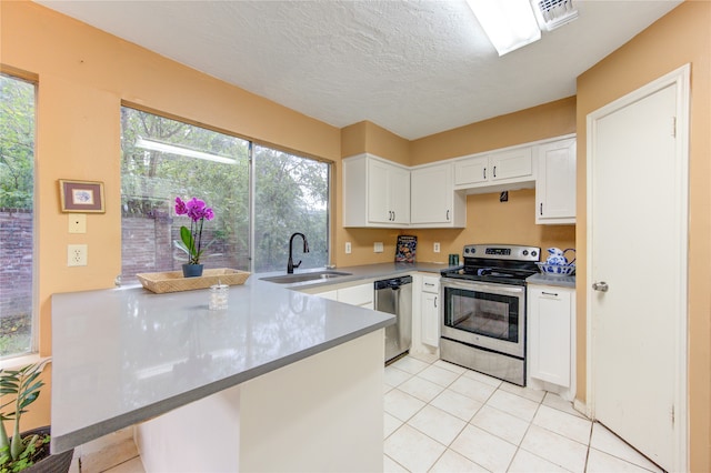 kitchen featuring stainless steel appliances, plenty of natural light, sink, and white cabinets