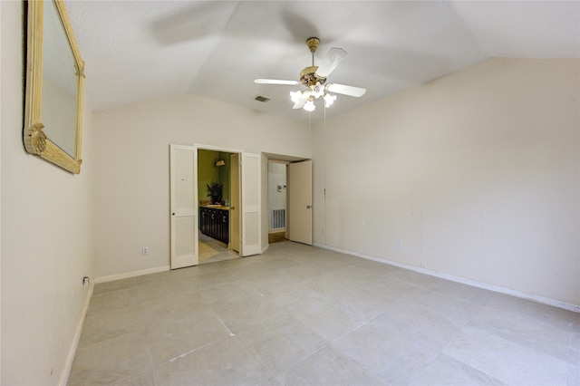 unfurnished bedroom with ensuite bathroom, ceiling fan, and vaulted ceiling