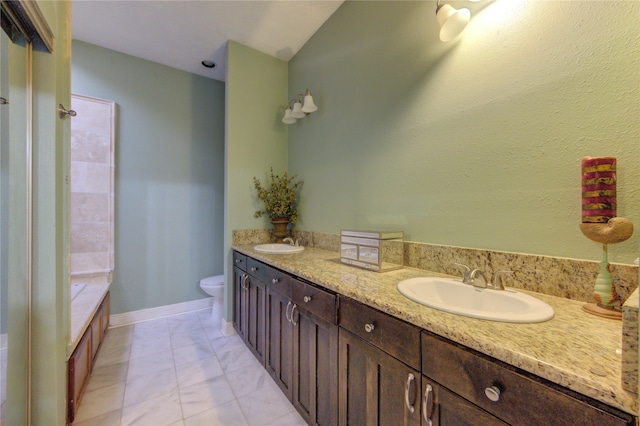 bathroom with toilet, a tub to relax in, vanity, and tile patterned floors