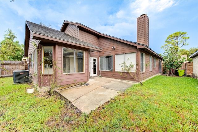 rear view of property featuring central air condition unit, a patio area, and a yard