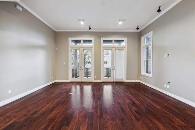 empty room featuring crown molding, a healthy amount of sunlight, and french doors