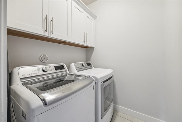 laundry area with cabinets, light tile patterned floors, and independent washer and dryer