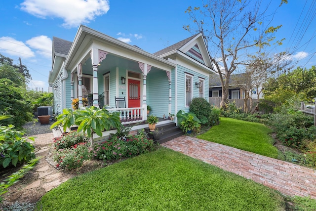 view of front facade with central AC unit, a front lawn, and covered porch