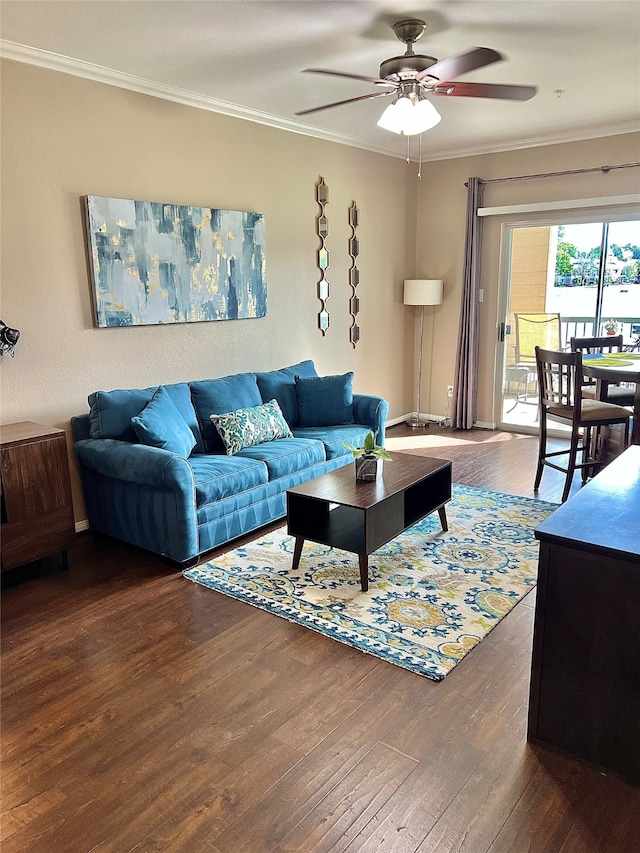 living room featuring ornamental molding, dark wood-type flooring, and ceiling fan