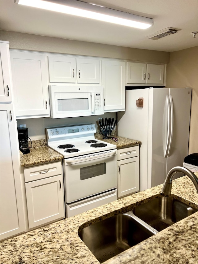 kitchen featuring white cabinetry, white appliances, sink, and light stone counters