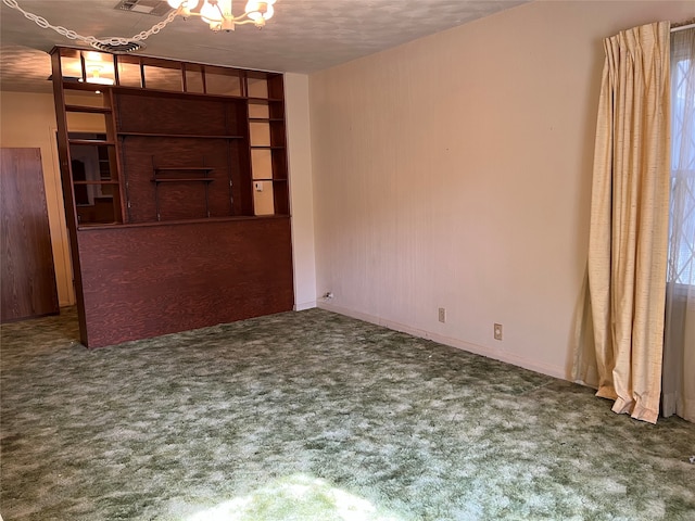 unfurnished room featuring carpet and a textured ceiling