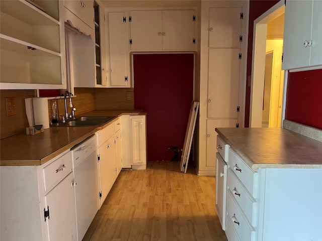 kitchen featuring light wood-type flooring, backsplash, white dishwasher, sink, and white cabinets