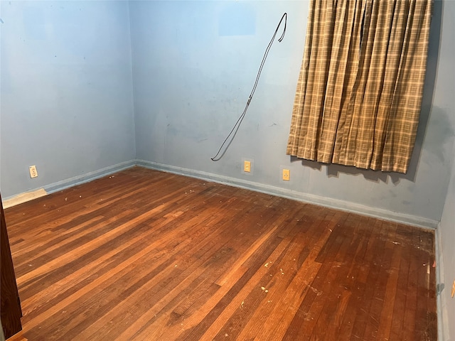 unfurnished room with dark wood-type flooring