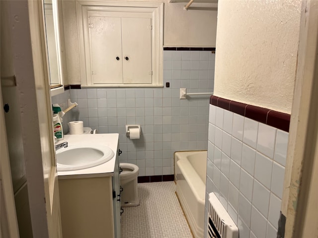 bathroom featuring radiator, vanity, tile walls, tile patterned flooring, and toilet