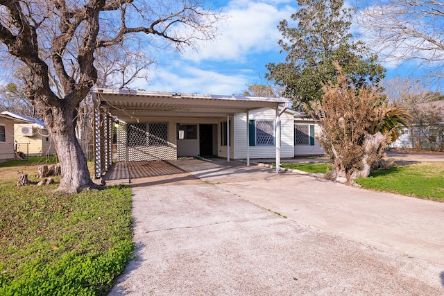 view of front of property featuring a front lawn and a carport