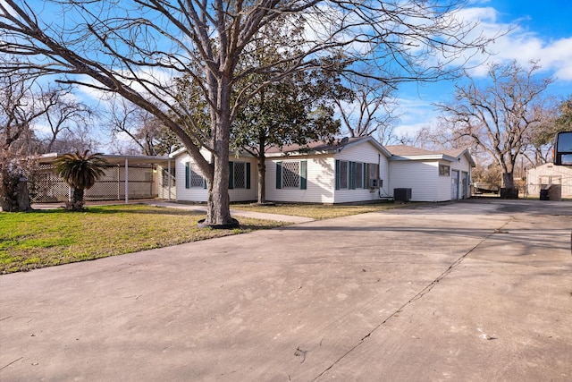 single story home with a carport, central AC, and a front lawn