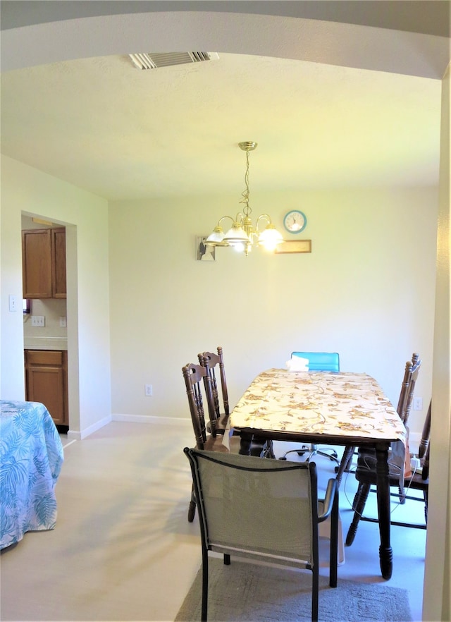 carpeted dining area featuring a chandelier