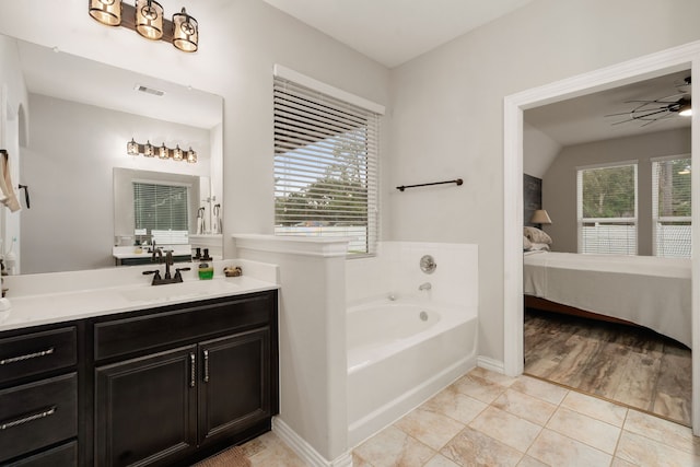 bathroom featuring ceiling fan, vanity, a healthy amount of sunlight, and hardwood / wood-style flooring