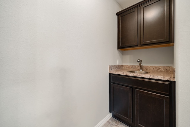 bar featuring dark brown cabinets and sink