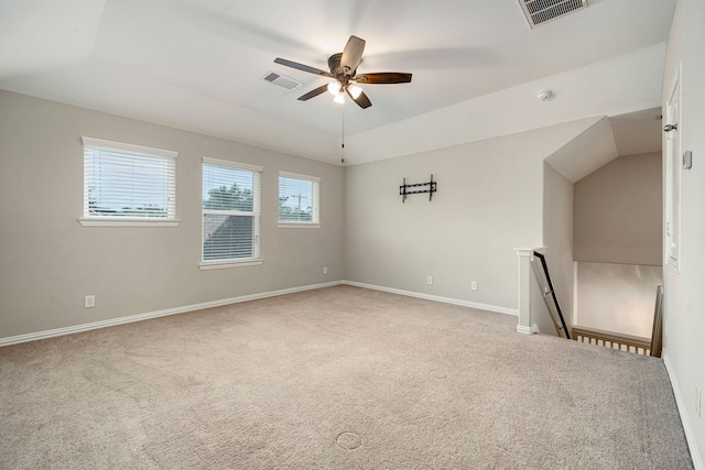 carpeted spare room featuring ceiling fan and lofted ceiling