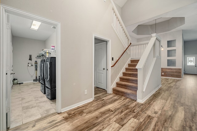 staircase with washer and dryer and wood-type flooring