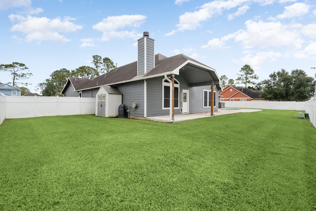 back of property featuring a lawn, a patio area, and a storage unit