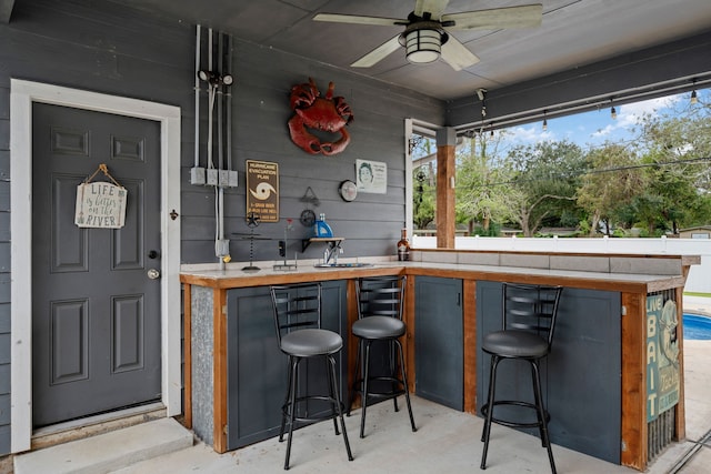 exterior space featuring ceiling fan, butcher block counters, and wood walls