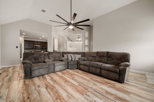 living room with light hardwood / wood-style floors, ceiling fan, and lofted ceiling