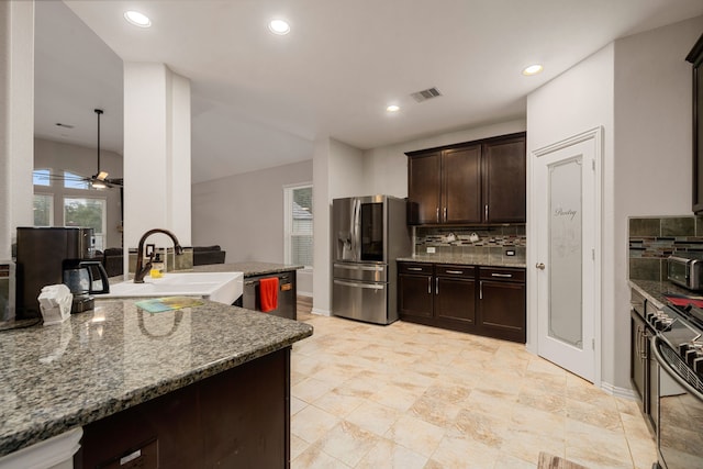 kitchen featuring dark stone counters, sink, ceiling fan, tasteful backsplash, and stainless steel appliances