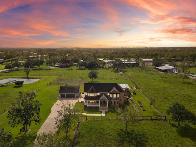 aerial view at dusk with a water view and a rural view