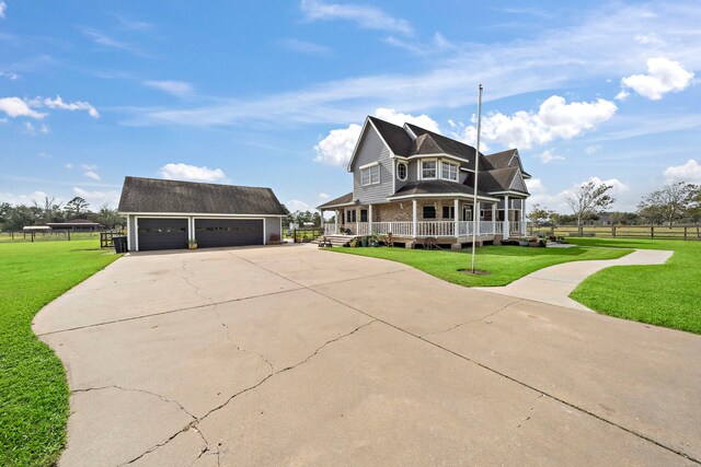 view of front of property with a porch, a front yard, a garage, and an outdoor structure