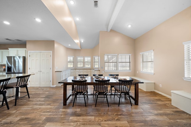 dining space featuring high vaulted ceiling, dark hardwood / wood-style flooring, and beam ceiling