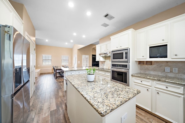 kitchen with black appliances, tasteful backsplash, a kitchen island, white cabinets, and dark hardwood / wood-style flooring