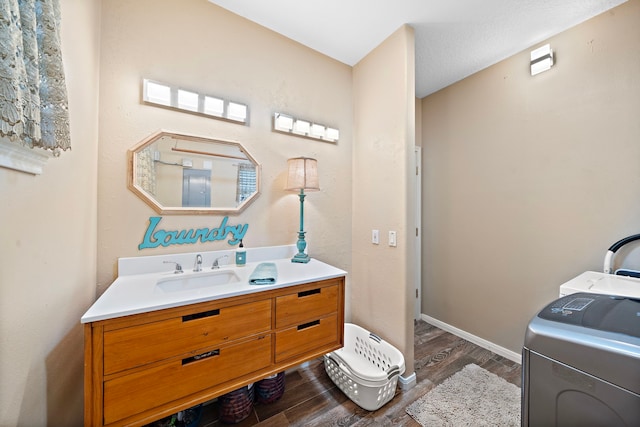 bathroom with washer / clothes dryer, vanity, hardwood / wood-style floors, and a textured ceiling