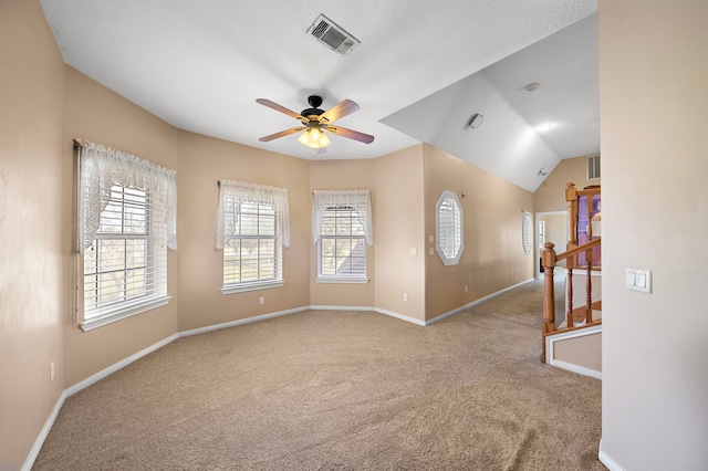 empty room featuring lofted ceiling, light carpet, and ceiling fan