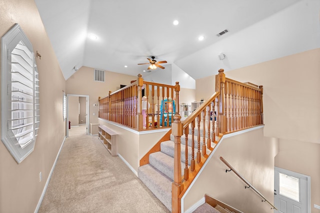 stairway with vaulted ceiling, carpet flooring, and ceiling fan