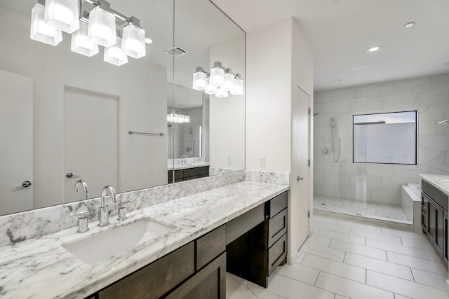 bathroom featuring vanity, tile patterned flooring, and tiled shower