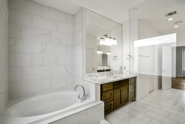 bathroom with vanity and a relaxing tiled tub