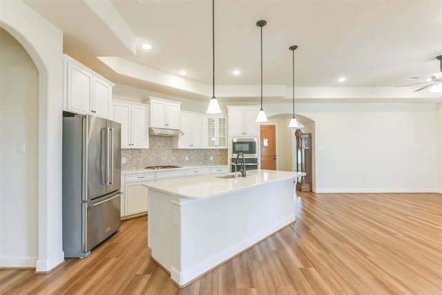 kitchen featuring light hardwood / wood-style flooring, pendant lighting, appliances with stainless steel finishes, and white cabinets