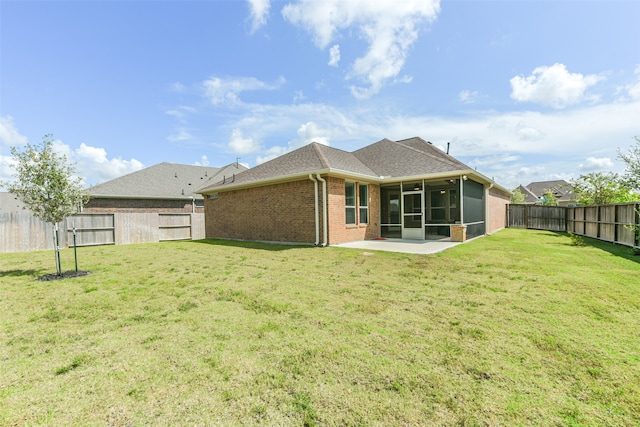 back of house with a lawn, a sunroom, and a patio area