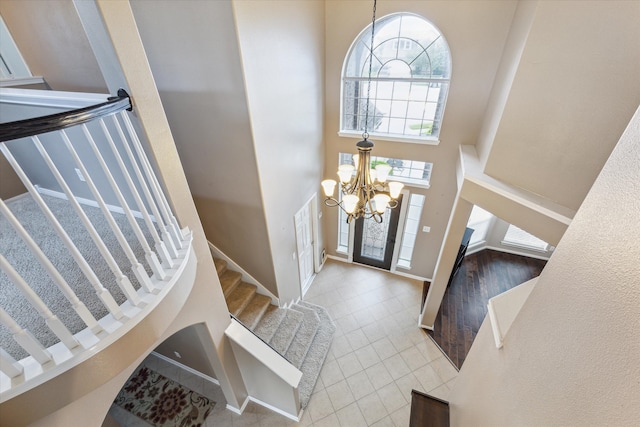 entryway featuring a towering ceiling and an inviting chandelier