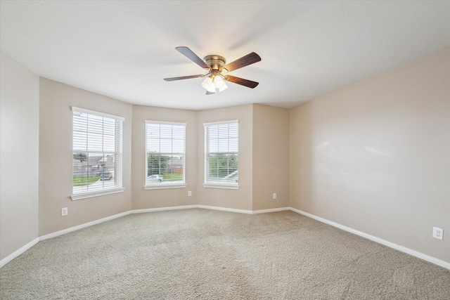 spare room with ceiling fan and carpet