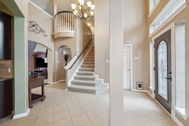 tiled foyer with a high ceiling and an inviting chandelier