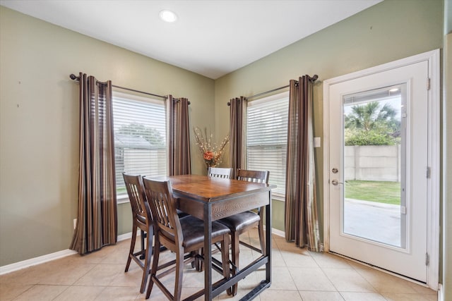 dining space with a wealth of natural light and light tile patterned flooring