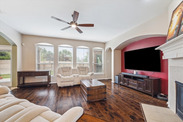 living room featuring dark hardwood / wood-style flooring, ceiling fan, and a fireplace