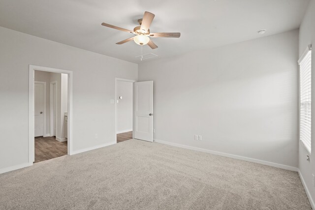 unfurnished bedroom with ceiling fan and dark carpet