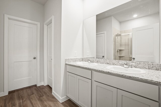 bathroom with hardwood / wood-style floors, walk in shower, and vanity