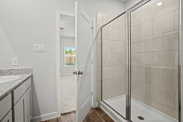 bathroom featuring hardwood / wood-style flooring, an enclosed shower, and vanity