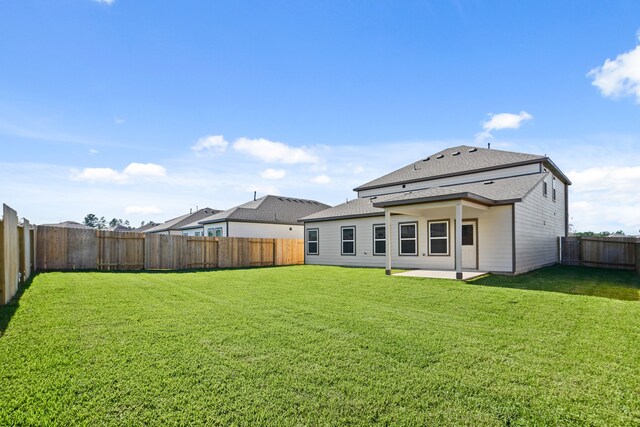 back of property featuring a patio area and a yard