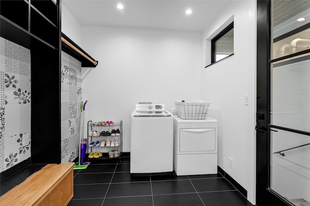 laundry area with dark tile patterned floors and washing machine and clothes dryer